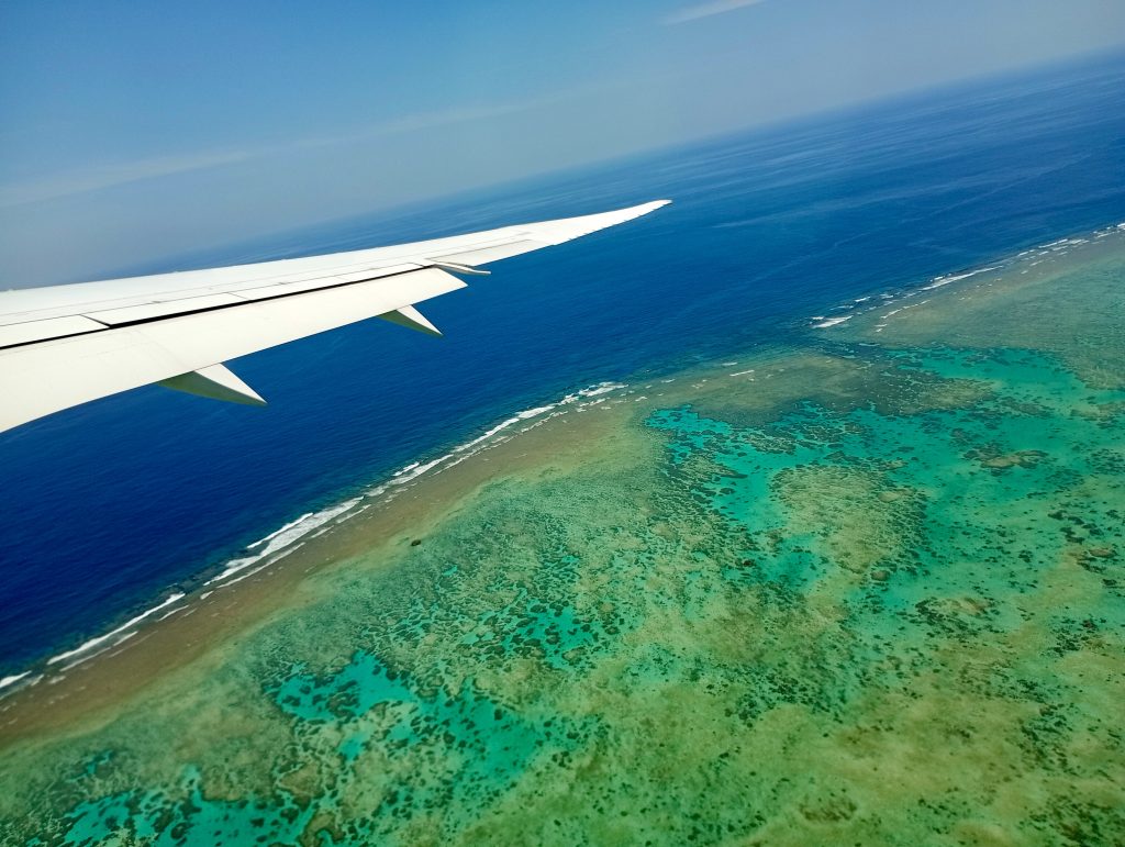 飛行機の窓から見た石垣島周辺のサンゴ礁の海