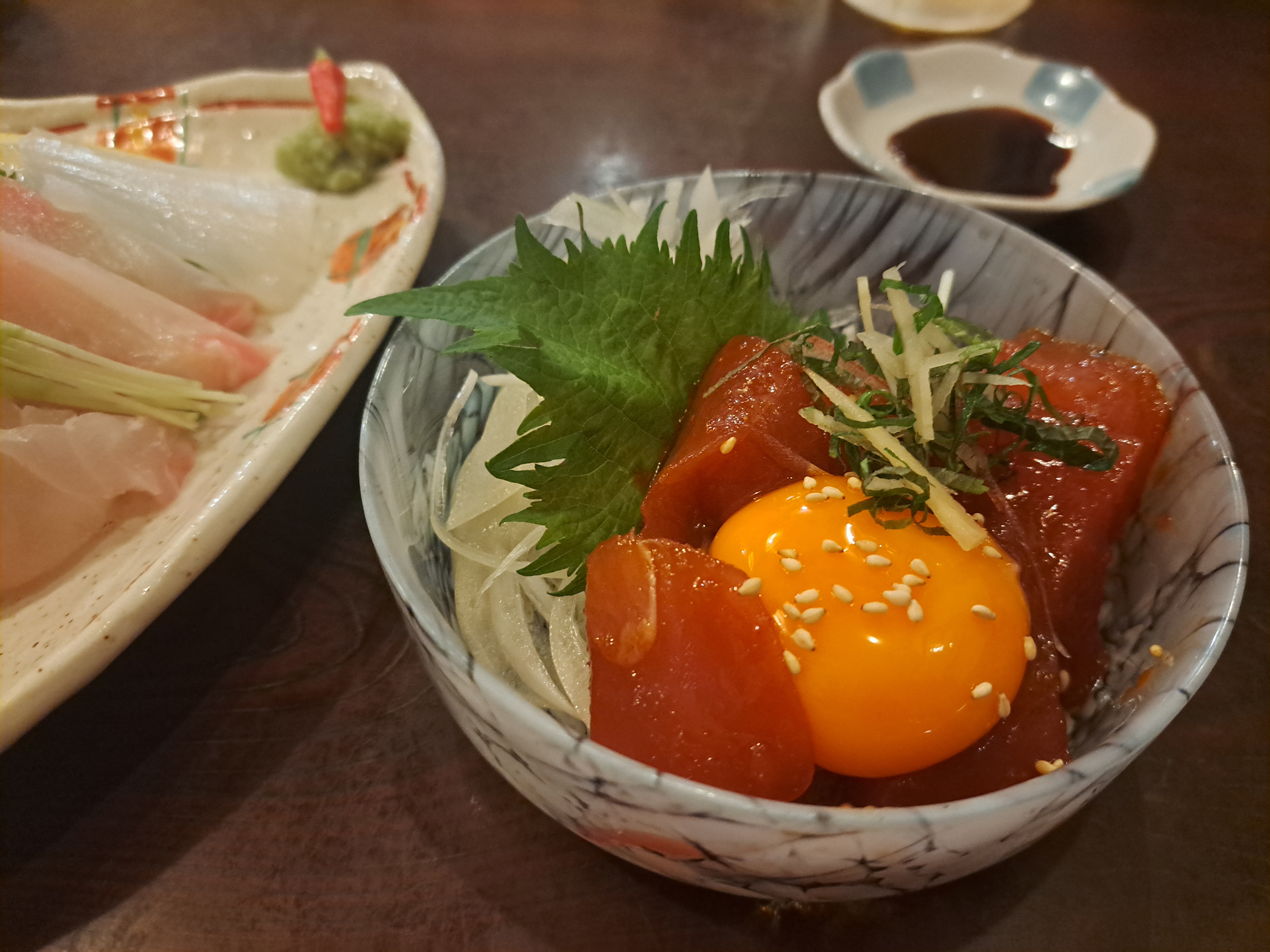 漬けマグロに卵黄をのせた小ぶりの丼と刺身